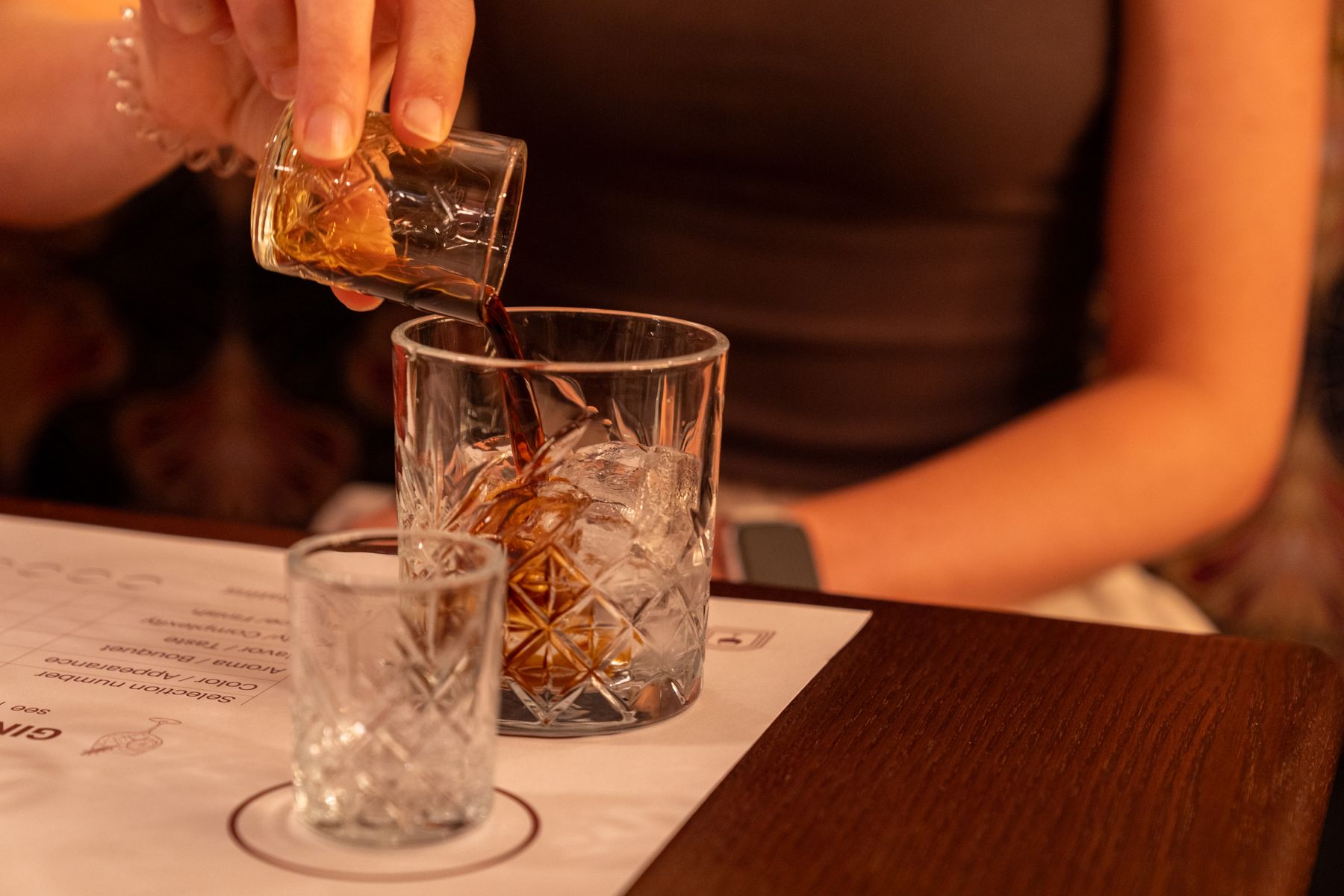 A Mallorcan gin and tonic being poured over ice in a cut glass tumbler