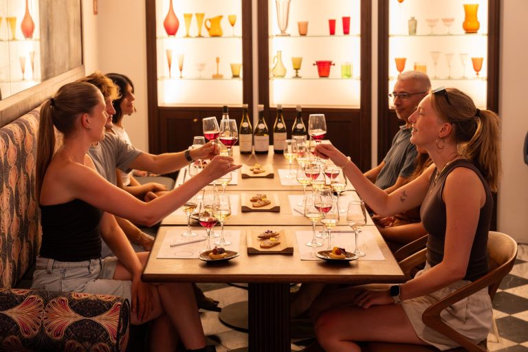 Group enjoying a Mallorcan wine tasting around a candle-lit long table at Tasting Palma