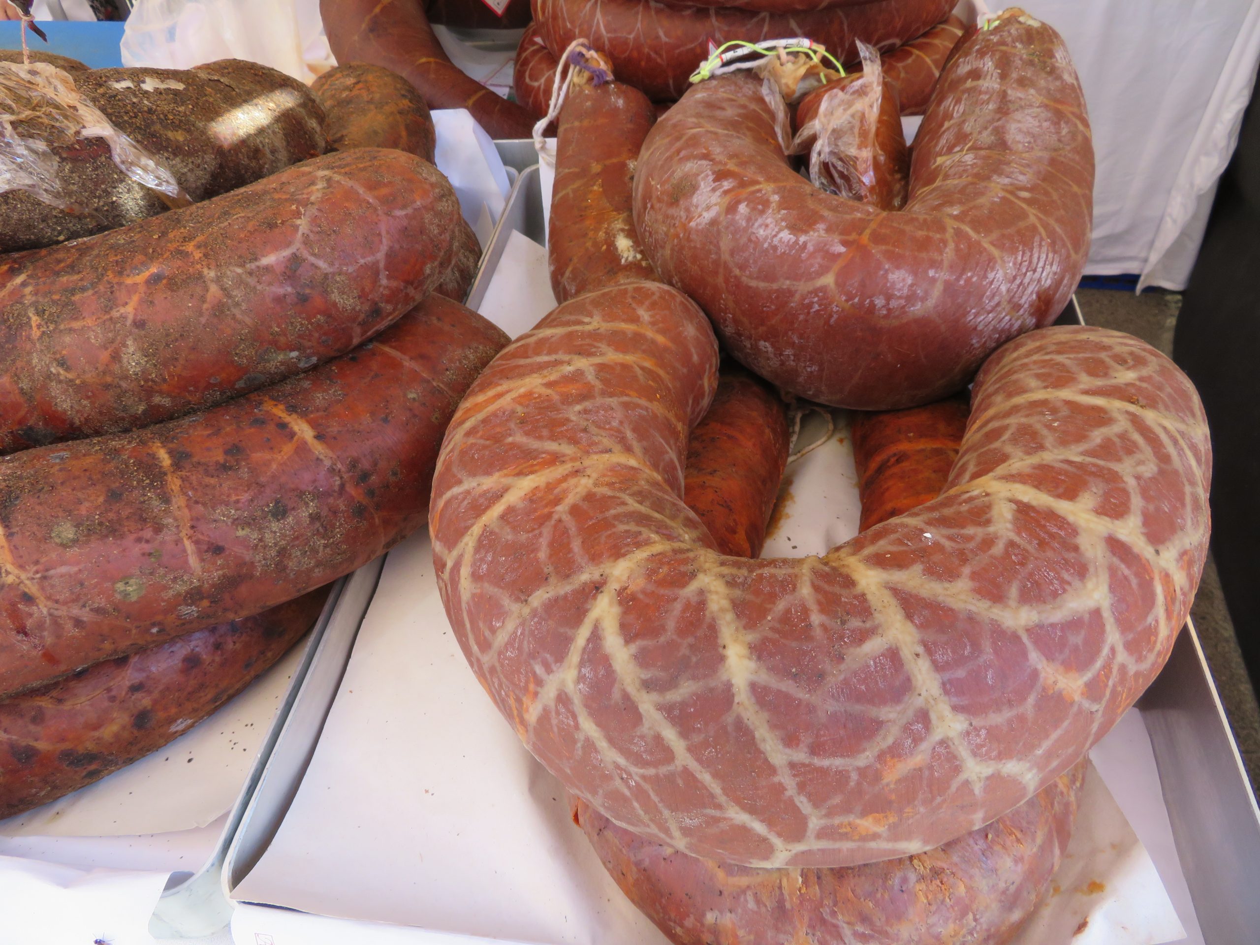 Sobrasada coiled in its natural casing on a market stall