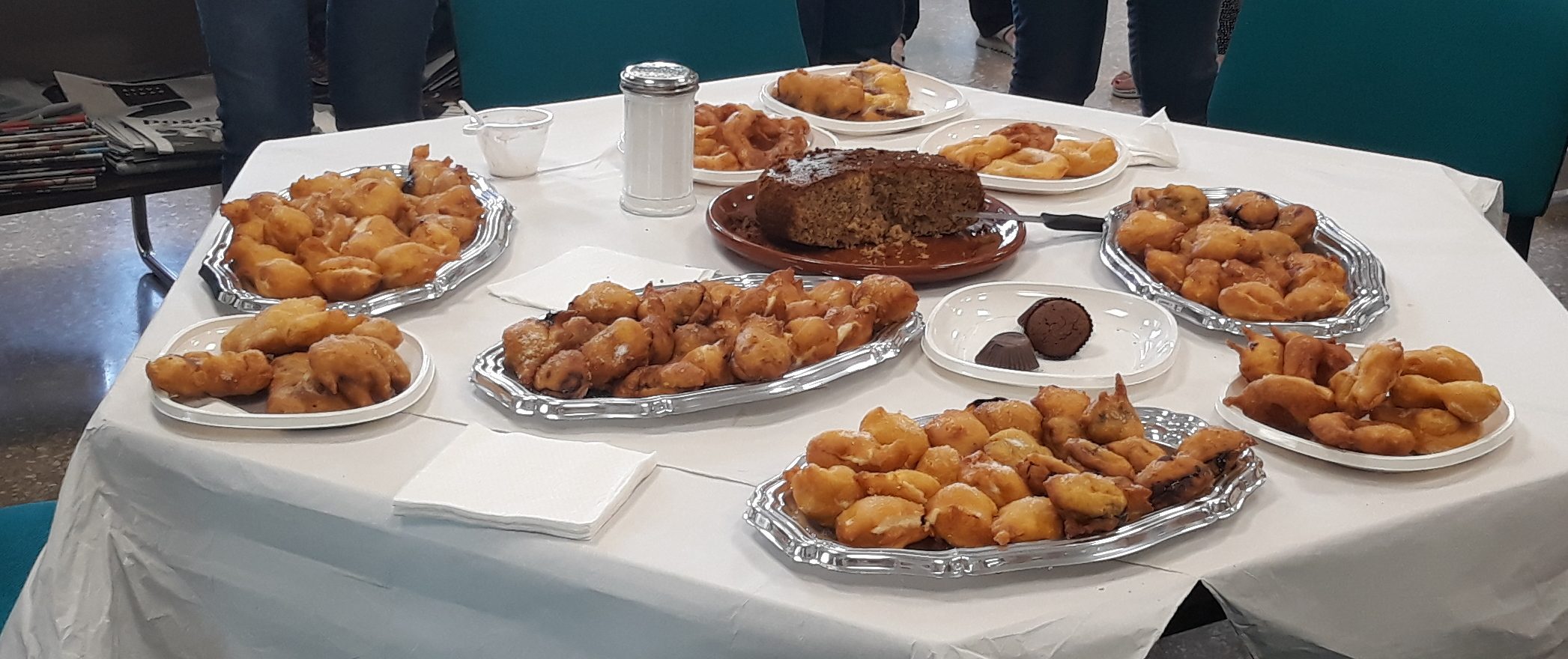 Trays of freshly fried bunyols laid out on a table